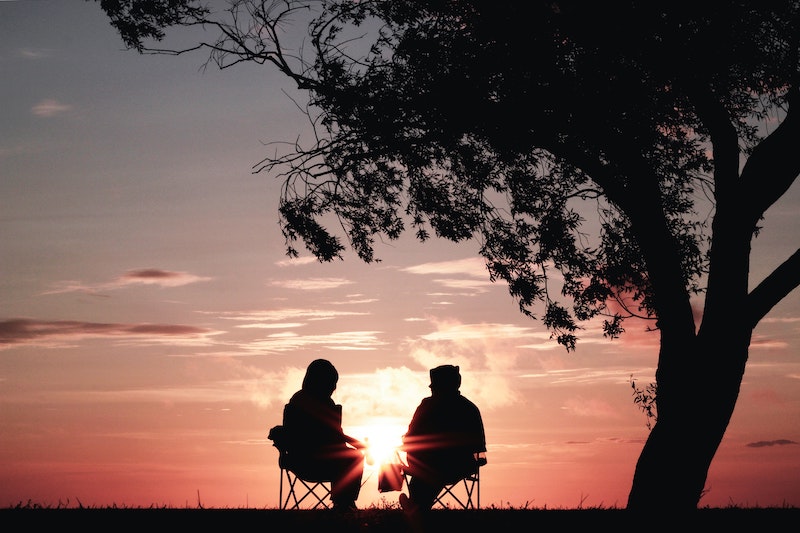 Talking-about-climate-change.jpg Two people backlit by pink sunset sitting in chairs under a tree